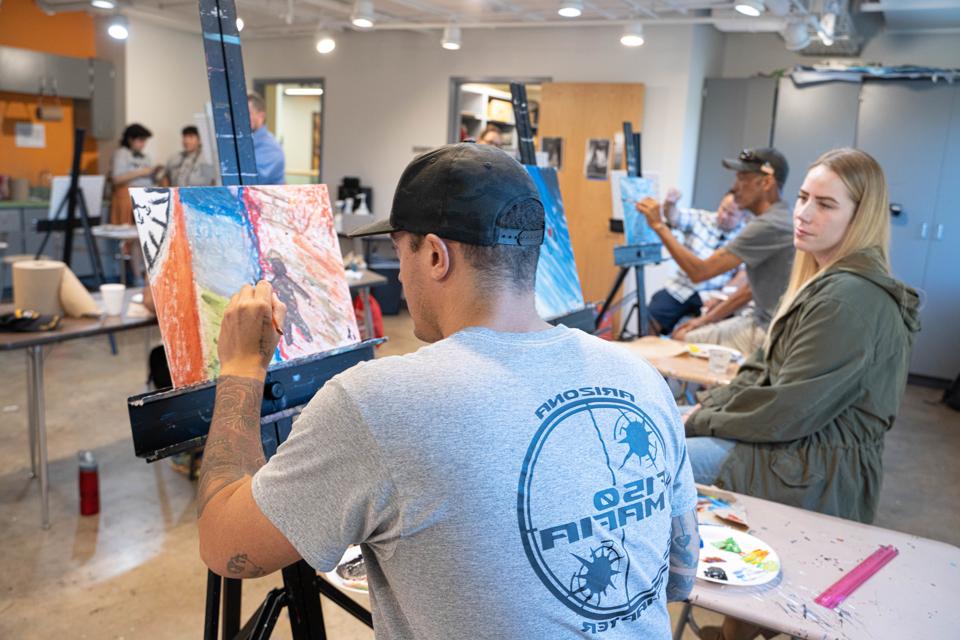 Male student veteran painting a canvas