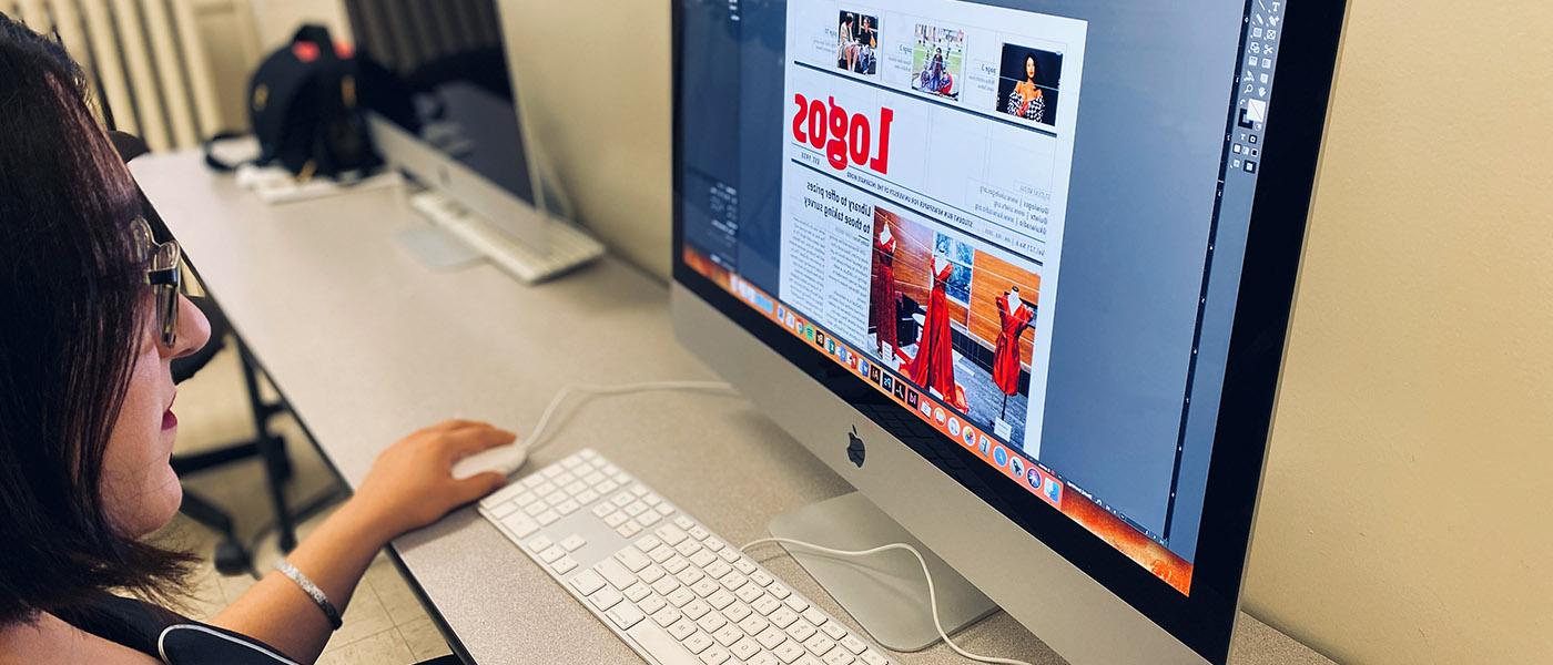 一个学生正在她的电脑上排版一份logo的报纸